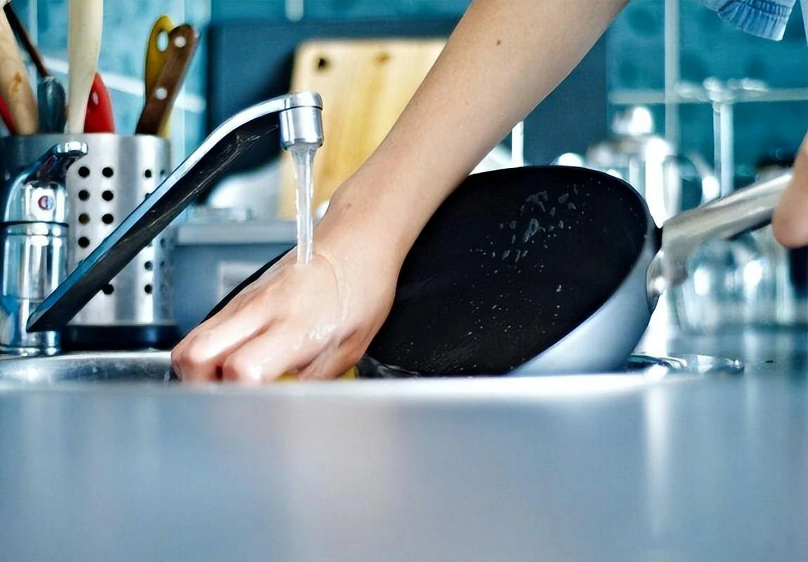 Why shouldn't you rinse an iron wok with water right after cooking?