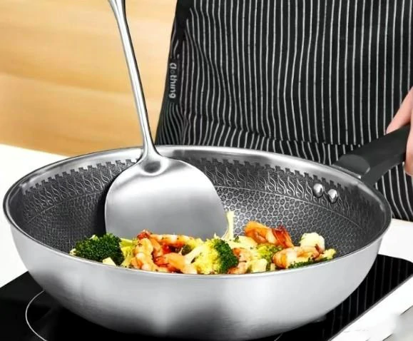 Why shouldn't you rinse an iron wok with water right after cooking?